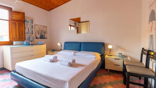 a bedroom with a bed with towels on it at Torre del Pozzo Seaview Retreat Sunset Terrace in S'archittu Cuglieri
