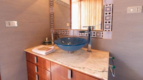 a bathroom with a blue sink and a mirror at Torre del Pozzo Seaview Retreat Sunset Terrace in S'archittu Cuglieri
