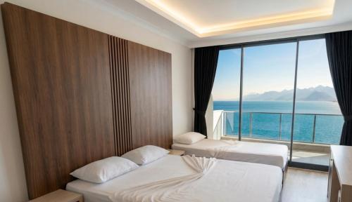 ein Hotelzimmer mit zwei Betten und einem großen Fenster in der Unterkunft Aperion Beach Hotel Side in Manavgat