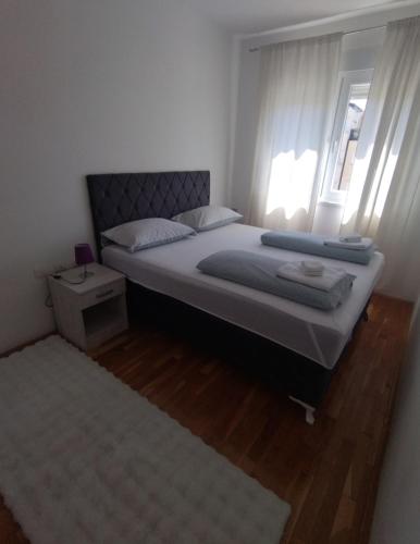 a bedroom with a large bed and a window at Apartman Natasha in Trebinje