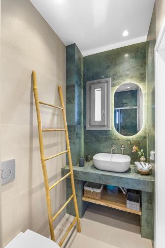 a bathroom with a sink and a mirror at Juniper View in Aspro Chorio Paros