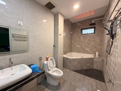a bathroom with a toilet and a sink and a tub at Permas Jaya Corner Homestay -Event -Party -TablePool -Karaoke -BBQ in Johor Bahru