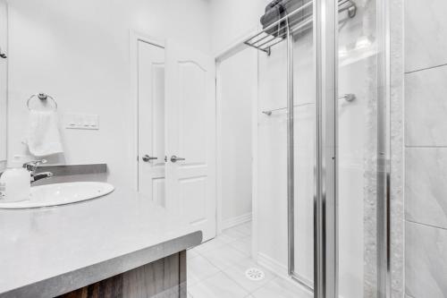 a white bathroom with a shower and a sink at spacious 3 bedroom space in Markham