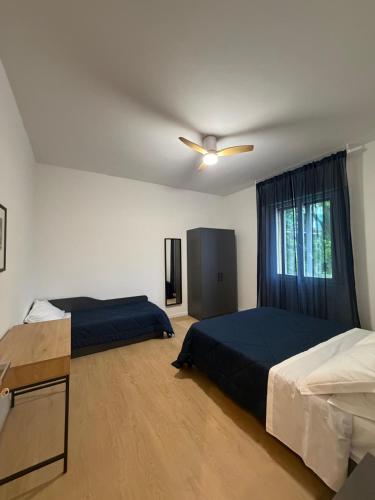 a bedroom with two beds and a ceiling fan at A CA' da 8 e Jacky in Casalecchio di Reno