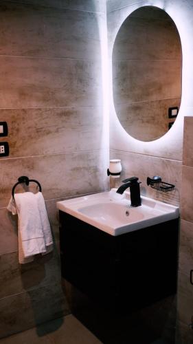 a bathroom with a sink and a round mirror at Madina Boutique Hotel in Luxor