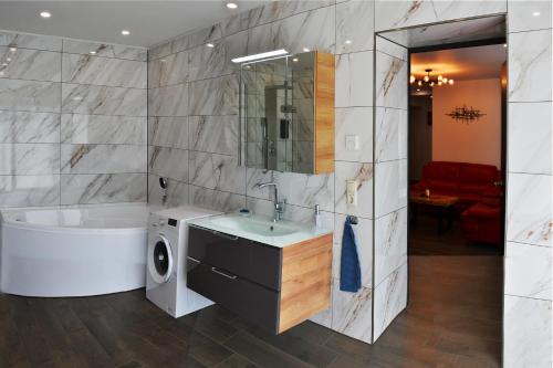 a bathroom with a tub and a sink and a bath tub at Martin Ferienhaus in Burg bei Magdeburg