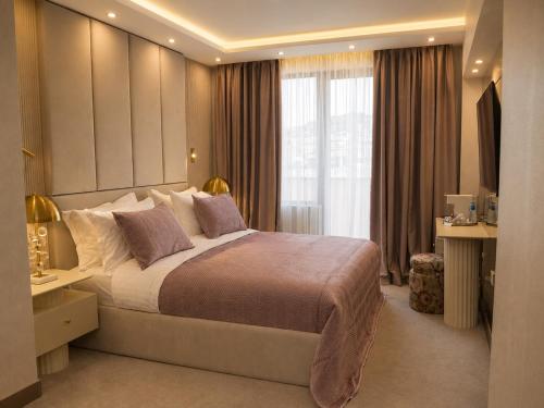 ein Schlafzimmer mit einem großen Bett und einem Fenster in der Unterkunft Spa Hotel Ezeretz Blagoevgrad in Blagoewgrad
