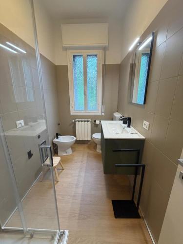 a bathroom with two sinks and a toilet and a shower at A CA' da 8 e Jacky in Casalecchio di Reno