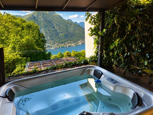 a bath tub with a view of a mountain at Essentia Guest House in Faggeto Lario 