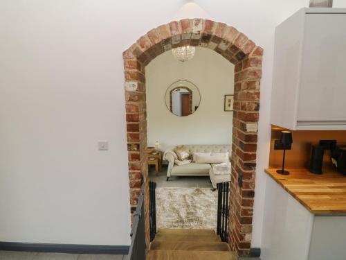 an archway leading into a living room with a couch at The Croft, Home Farm in Ripley