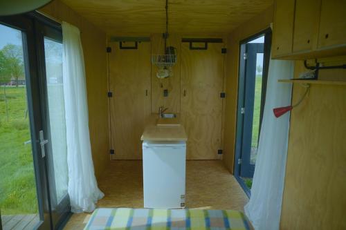 a bathroom with a sink in a small house at De IJsvogel in Wijdewormer