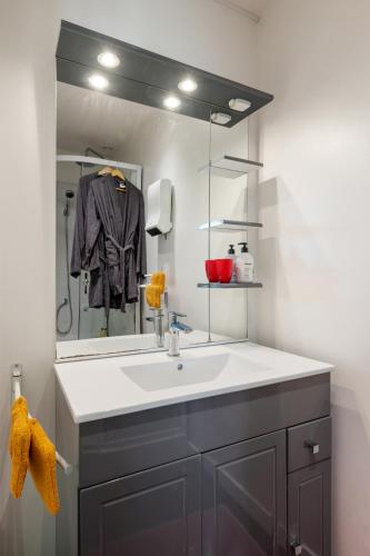 a bathroom with a sink and a mirror at L'instant présent in Hautot-lʼAuvray