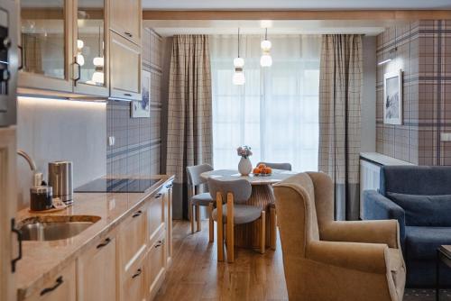 a kitchen with a table and chairs in a room at Rezydencja Sienkiewicza in Zakopane