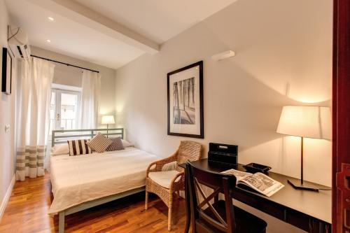 1 dormitorio con 1 cama y escritorio con escritorio en Appartamento con vista sul Vittoriano, en Roma