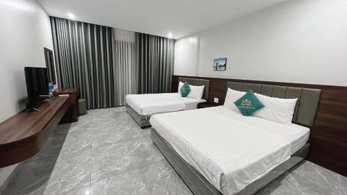 a hotel room with two beds and a television at Tuần Châu HQT in Ha Long