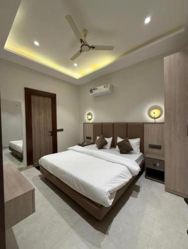 a bedroom with a large white bed with a ceiling at Hotel sky inn in Jalandhar