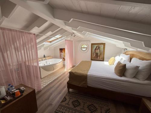 a bedroom with a large bed and a bath tub at Rebetiko Hotel in Alaçatı
