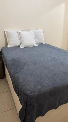 a bed with a blue blanket on top of it at Na Ladeira Studio 02 in Rio de Janeiro