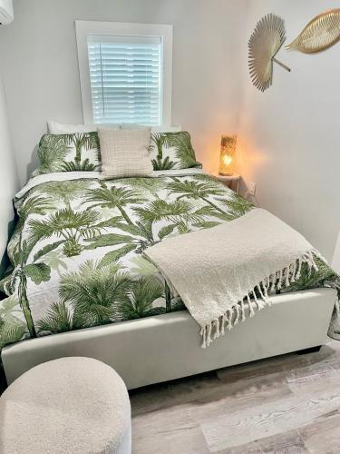 a bedroom with a bed with a palm tree bedspread at Lil' Beach Getaway in Jacksonville Beach