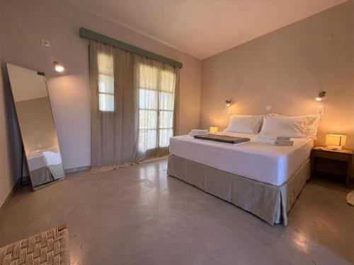 a bedroom with a large bed and a large window at Medina in Skala