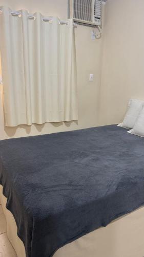 a bedroom with a bed with a blue blanket on it at Na Ladeira Studio 02 in Rio de Janeiro