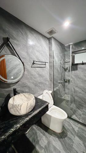 a bathroom with a toilet and a sink and a shower at Tuần Châu HQT in Ha Long