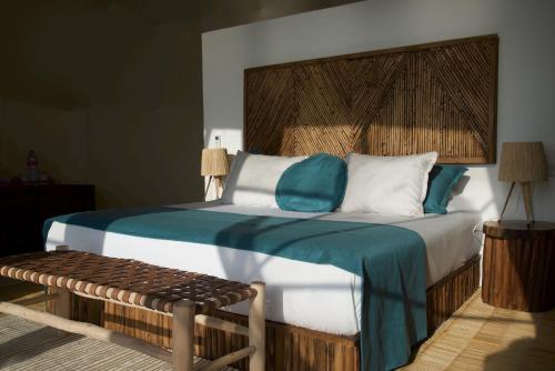 a bedroom with a bed with a wooden headboard and a bench at Ksar Massa in Rbat