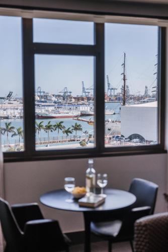 a table in a room with a view of a harbor at Poem Suites by Airnest in Las Palmas de Gran Canaria
