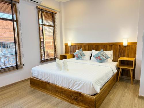 a bedroom with a large bed with white sheets at Wansuk Chiangkhan in Chiang Khan