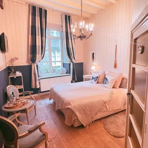a bedroom with a bed and a chandelier at B&B Con Ampère in Bruges