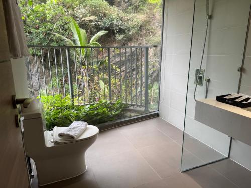 a bathroom with a toilet and a glass shower at Sky villa on the beach in Cat Ba