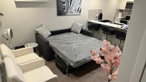 a small room with a bed and two chairs at Comfy-home in YYC