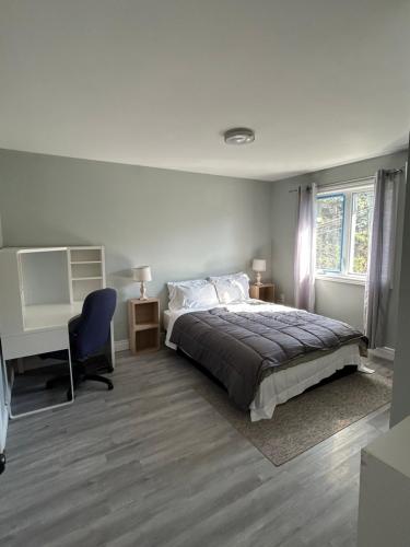 a bedroom with a bed and a desk and a computer at Modern Queen St Duplex 4BRs in Charlottetown