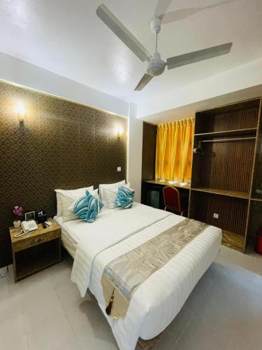 a bedroom with a large white bed with blue pillows at ZAN Lodge in Male City