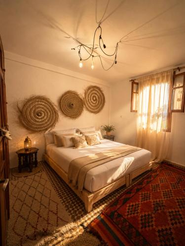 a bedroom with a bed and a chandelier at Riad Boya Surf - Lodge in Agadir