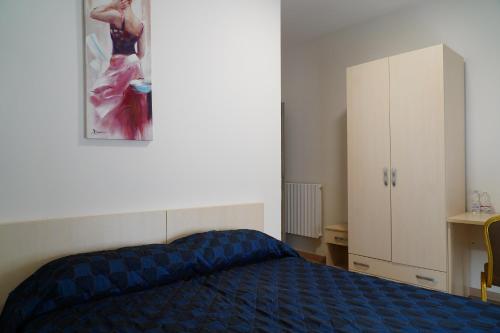 a bedroom with a bed and a painting on the wall at B e B LEMI in Ponte