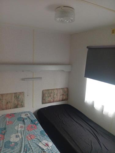 a small bedroom with a bed and a window at Camping les sumacs in Combles