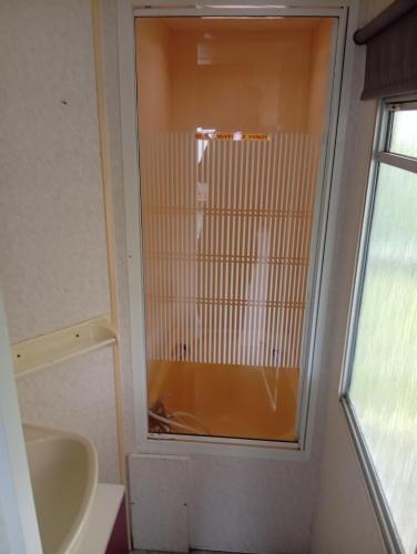 a bathroom with a shower and a sink at Camping les sumacs in Combles