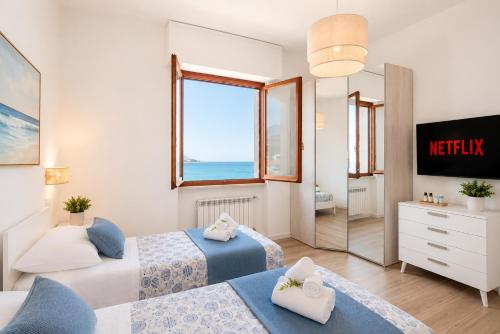 a hotel room with two beds and a mirror at You and the Sea in Savona