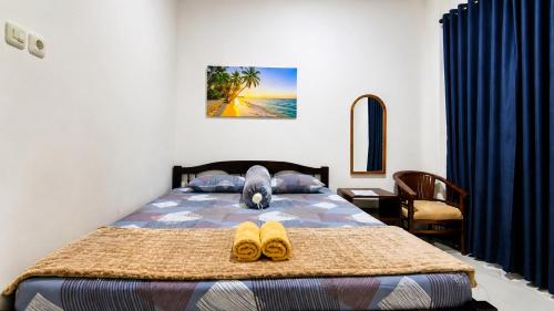 a bedroom with a bed with two shoes on it at Griya Mentari Homestay in Yogyakarta