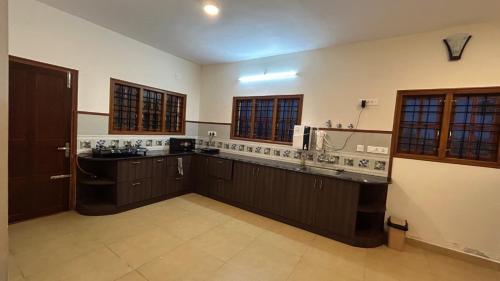 a large kitchen with brown cabinets and a sink at Villa Bella in Ooty