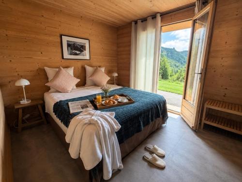 a bedroom with a bed with a tray of food on it at La Framboiseille - Chalet de Luxe avec Piscine Intérieure et Sauna - Vue Montagne in Manigod