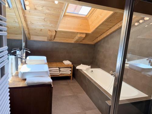 a bathroom with a toilet and a tub and a sink at La Framboiseille - Chalet de Luxe avec Piscine Intérieure et Sauna - Vue Montagne in Manigod
