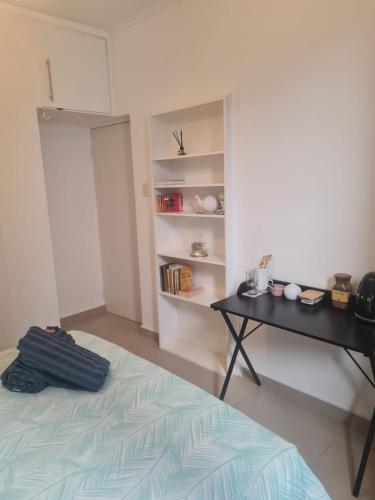 a bedroom with a desk and a bed and a table at Comfortable Secure Business Stay in Johannesburg