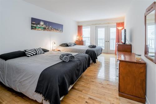 a bedroom with two beds and a television in it at Charming Condo - Perfect for Visiting Quebec City in Quebec City