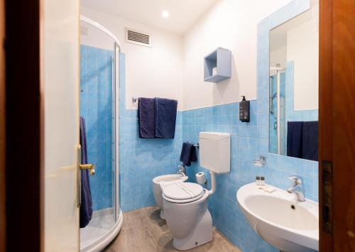 a blue tiled bathroom with a toilet and a sink at Hotel Oceano in Marina di Pietrasanta