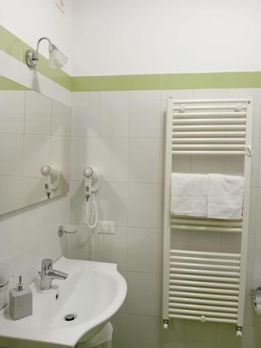 ein weißes Badezimmer mit Waschbecken und Spiegel in der Unterkunft Room 119 in Tortoreto Lido