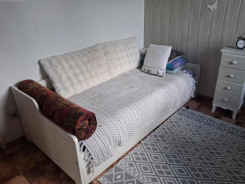 a white couch in a room with a dresser at Chambre in Saint-Georges-du-Bois