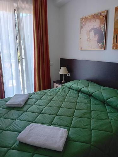 ein Schlafzimmer mit einem grünen Bett mit zwei Handtüchern darauf in der Unterkunft Room 119 in Tortoreto Lido