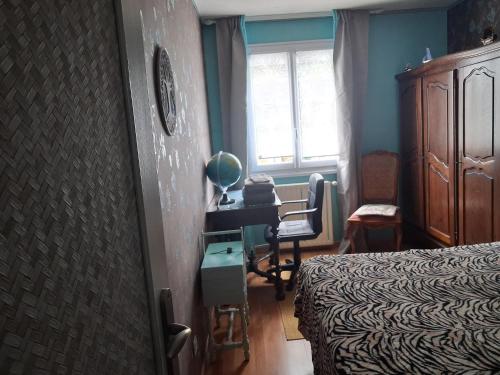 a bedroom with a bed and a desk and a window at Chambre in Saint-Georges-du-Bois